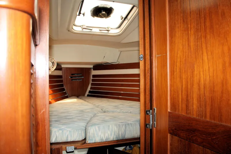 Slide: The Image of Interior cabin of 1988 Pearson 31 sailboat with wooden finish and cozy bedding. - 25