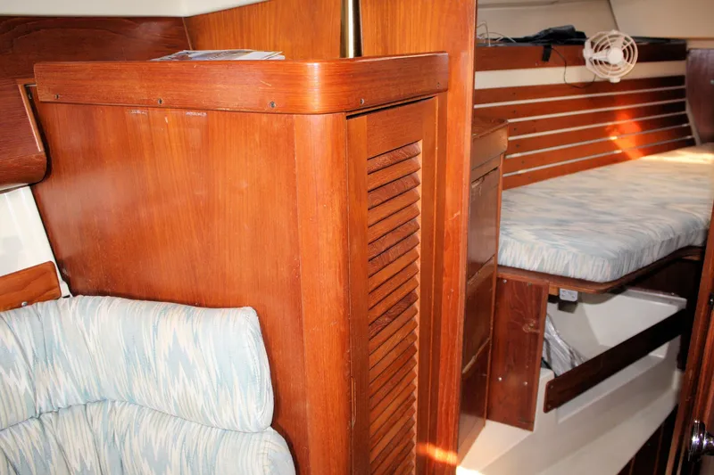 Slide: The Image of Interior of 1988 Pearson 31 sailboat with wooden cabinetry and cushioned seating. - 26