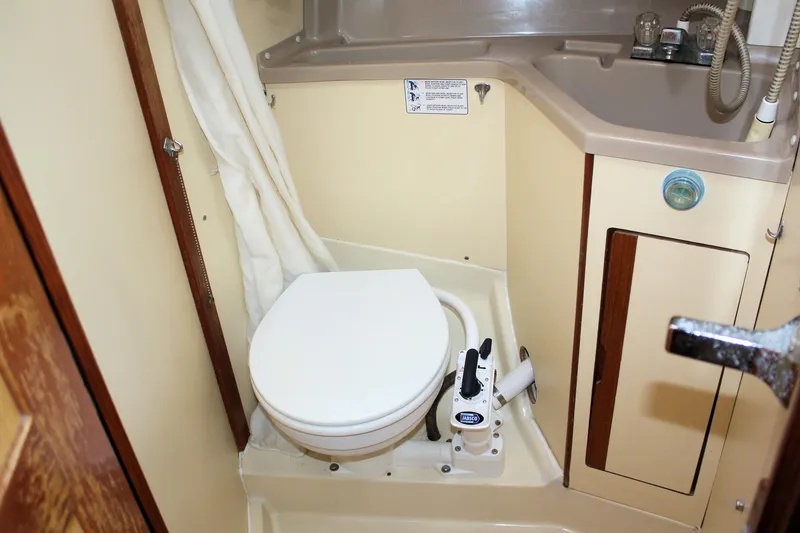 Slide: The Image of 1988 Pearson 31 sailboat bathroom with compact marine toilet and sink. - 27