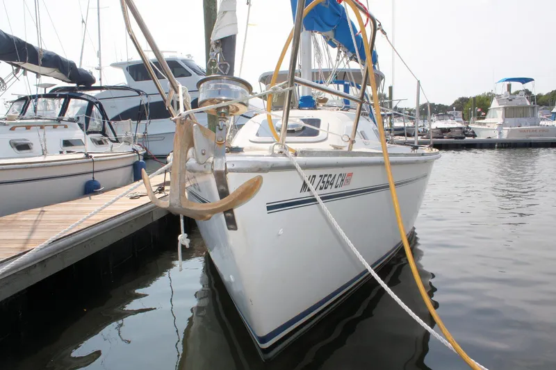 Slide: The Image of 1988 Pearson 31 sailboat docked at marina, featuring anchor and mooring lines. - 3