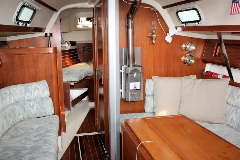 Slide: The Image of Interior of a 1988 Pearson 31 sailboat with cozy seating and wooden finishes. - 31