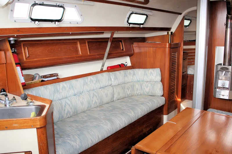 Slide: The Image of Interior of a 1988 Pearson 31 sailboat with wood finish and cushioned seating. - 34