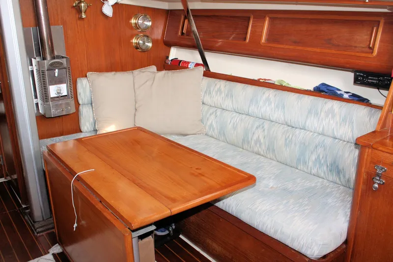 Slide: The Image of Interior of 1988 Pearson 31 sailboat with wooden table and cushioned seating. - 35