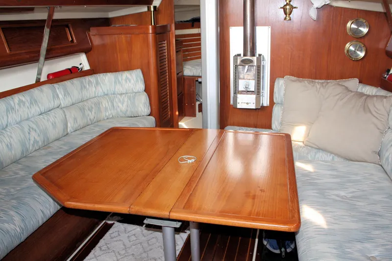 Slide: The Image of Interior of a 1988 Pearson 31 sailboat with wooden table and cushioned seating. - 36