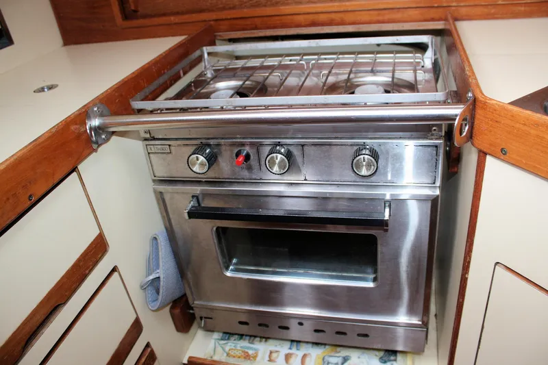 Slide: The Image of Stainless steel stove in 1988 Pearson 31 yacht kitchen, featuring wooden cabinetry. - 39