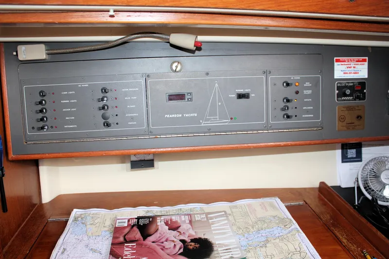 Slide: The Image of Control panel of a 1988 Pearson 31 yacht with navigation charts and magazine. - 43