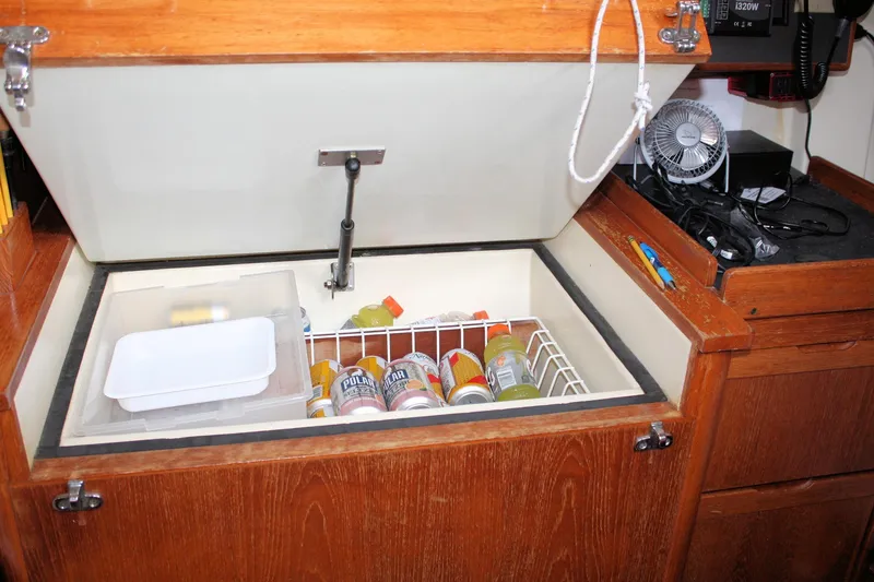 Slide: The Image of Interior of 1988 Pearson 31 sailboat with open storage compartment and beverages. - 47