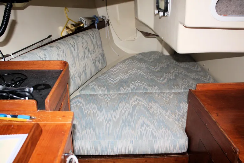 Slide: The Image of 1988 Pearson 31 sailboat interior with patterned cushions and wooden cabinetry. - 50
