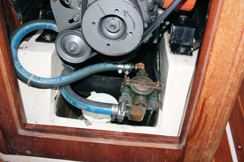 Slide: The Image of Engine compartment of a 1988 Pearson 31 sailboat, showing hoses and mechanical components. - 55