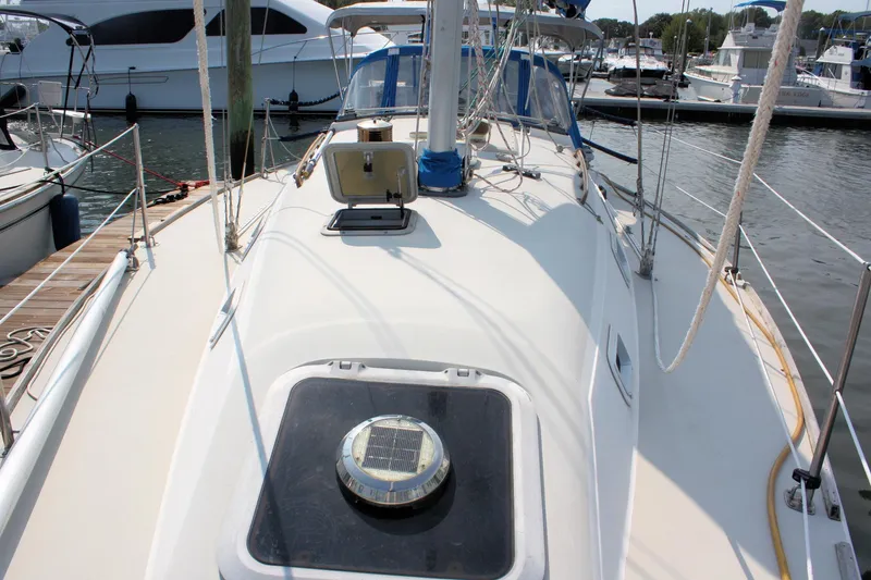 Slide: The Image of 1988 Pearson 31 sailboat deck view at marina, showcasing hatch and rigging. - 8