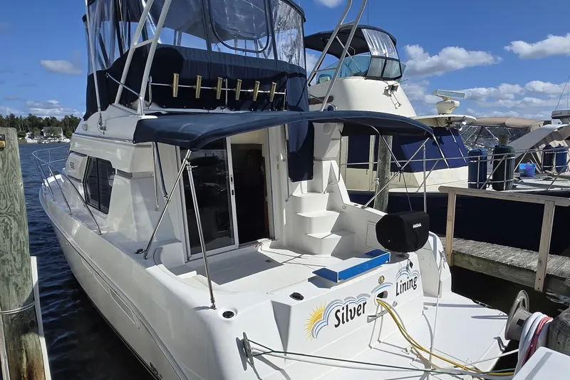The Image of 2002 Silverton 351 Sedan Cruiser docked at marina under clear blue sky. - 0