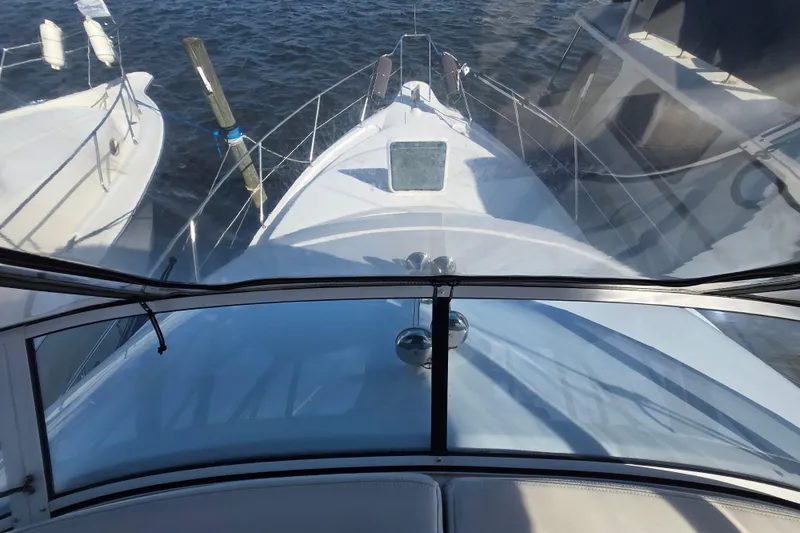 Slide: The Image of 2002 Silverton 351 Sedan Cruiser docked, viewed from the helm, surrounded by water. - 12