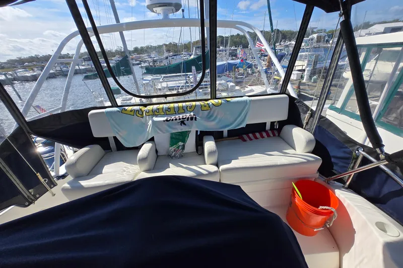 Slide: The Image of 2002 Silverton 351 Sedan Cruiser interior with seating, docked at marina, sunny day. - 13