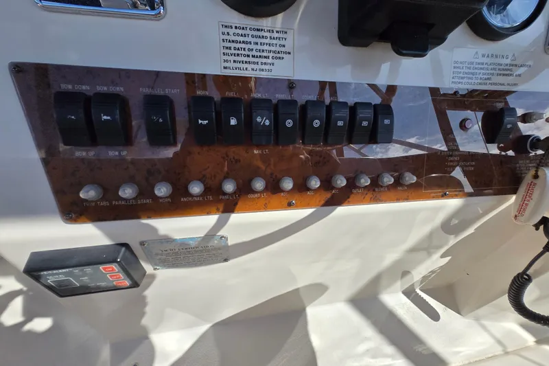 Slide: The Image of Control panel of a 2002 Silverton 351 Sedan Cruiser with various switches and labels. - 18