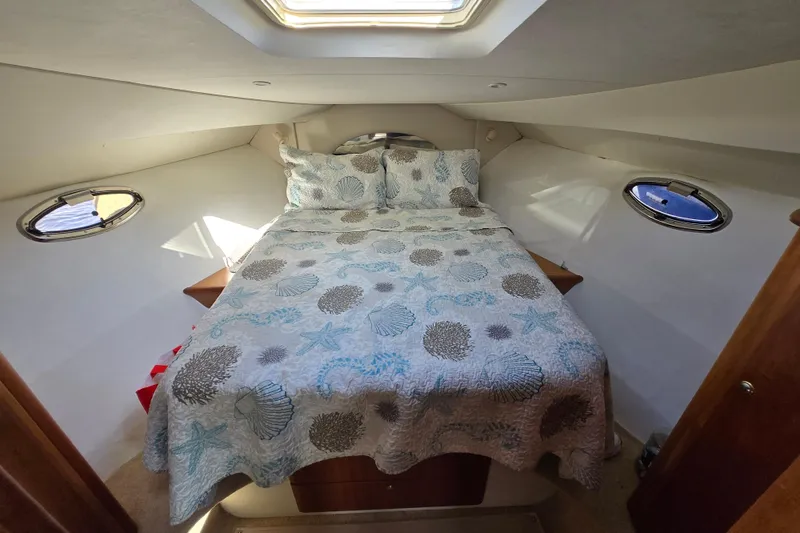 Slide: The Image of 2002 Silverton 351 Sedan Cruiser cabin with bed and nautical-themed bedding. - 23