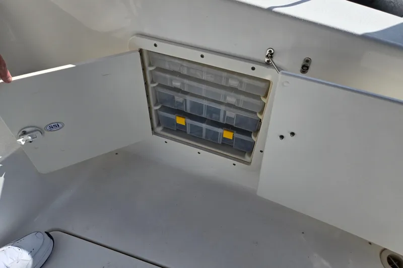 Slide: The Image of 2002 Silverton 351 Sedan Cruiser storage compartment with organized tackle boxes. - 28