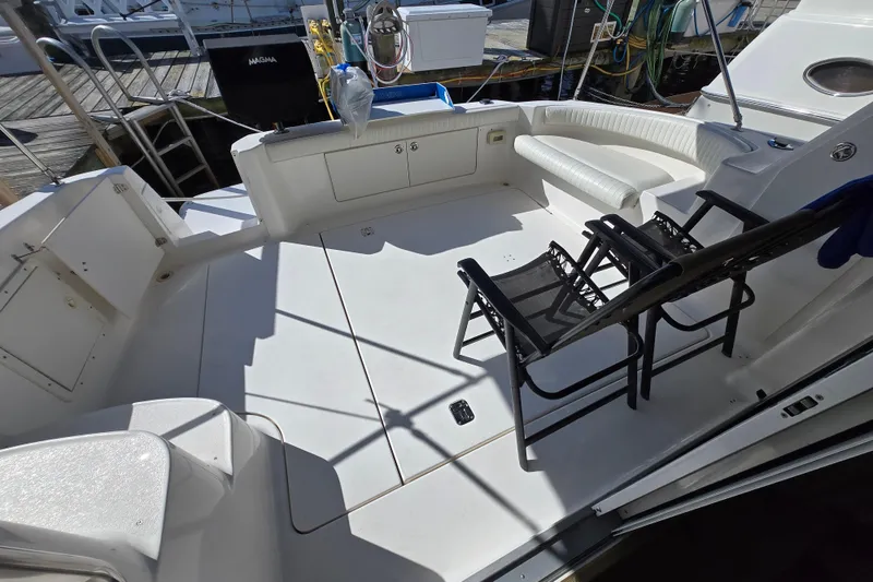 Slide: The Image of 2002 Silverton 351 Sedan Cruiser deck with seating and chairs, docked at marina. - 6