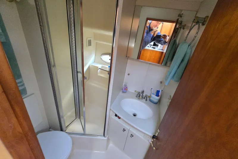 Slide: The Image of 2002 Silverton 351 Sedan Cruiser bathroom with shower, sink, and mirror. - 7