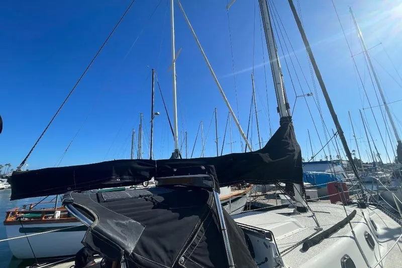 Slide: The Image of Sailboat Custom Bodega 30, 1977 model, docked in marina under clear blue sky. - 1