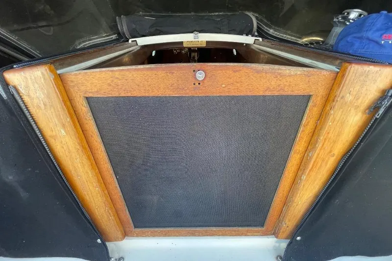 Slide: The Image of Wooden hatch of a 1977 Custom Bodega 30 boat, featuring a mesh screen. - 11