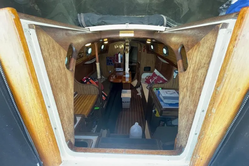 Slide: The Image of Interior view of a 1977 Custom Bodega 30 sailboat, featuring wooden finishes and compact design. - 12