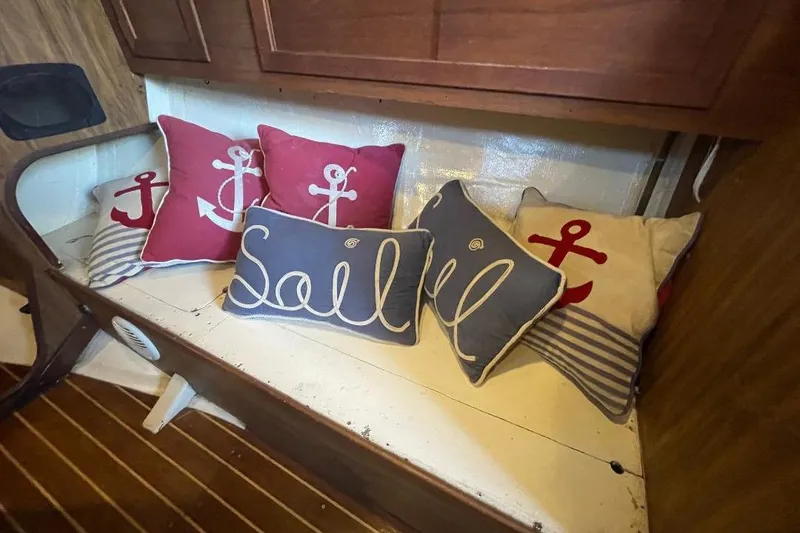Slide: The Image of Nautical-themed cushions on a wooden bench inside a 1977 Custom Bodega 30 boat. - 14