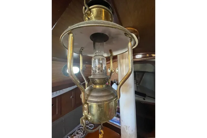 Slide: The Image of Vintage brass lantern inside a 1977 Custom Bodega 30 boat cabin. - 15