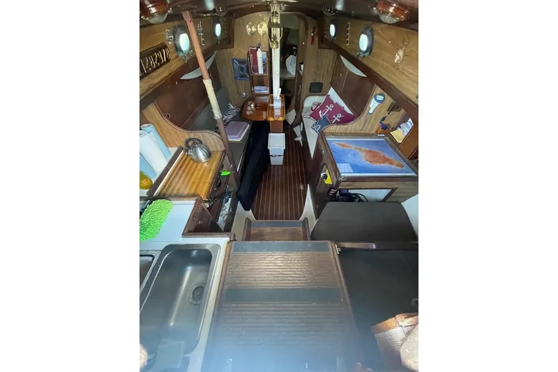 Slide: The Image of Interior of 1977 Custom Bodega 30 sailboat with wooden finishes and nautical decor. - 16