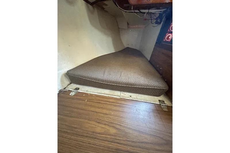 Slide: The Image of 1977 Custom Bodega 30 interior cabin with brown cushion and wooden flooring. - 23