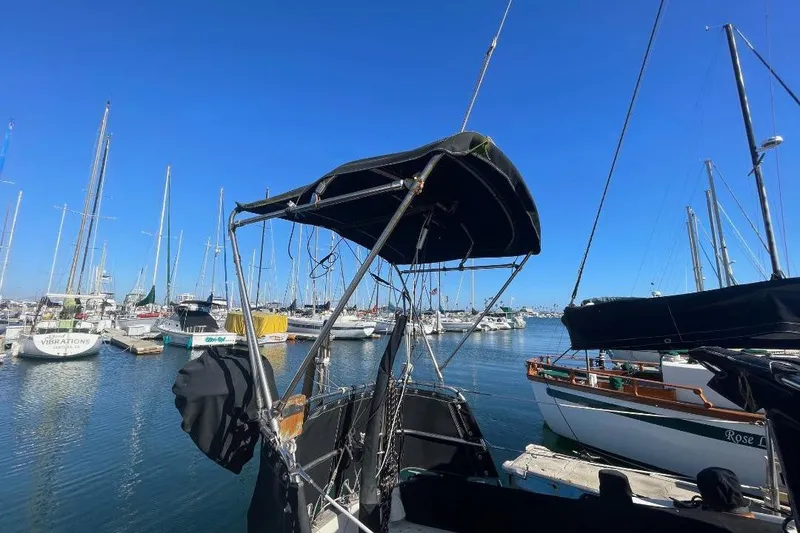 Slide: The Image of Sailboats docked at a marina under clear blue skies, featuring a 1977 Custom Bodega 30. - 3