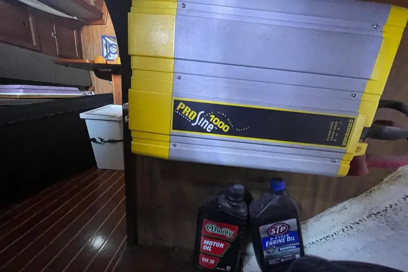 Slide: The Image of Yellow ProSine 1000 inverter in a 1977 Custom Bodega 30 interior with motor oil containers. - 33