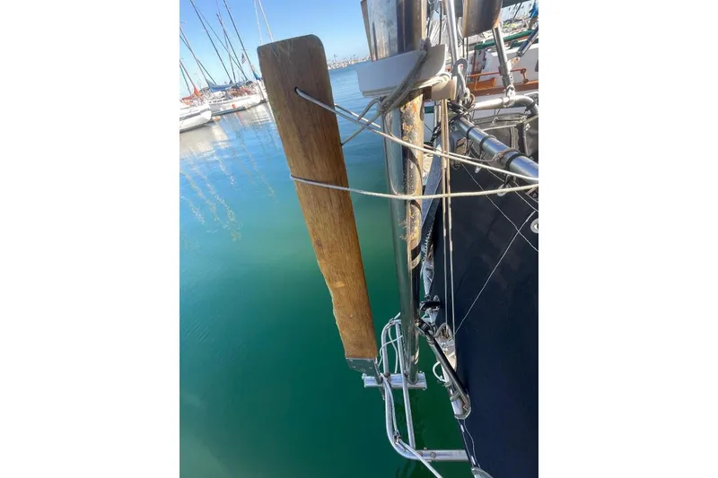 Slide: The Image of Custom Bodega 30 sailboat detail, 1977 model, docked in a marina with clear water. - 43