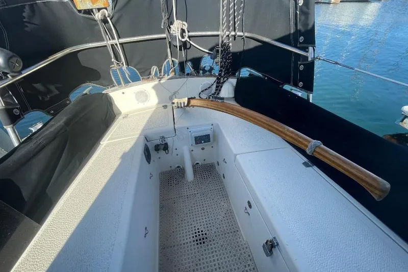 Slide: The Image of Cockpit of 1977 Custom Bodega 30 sailboat with wooden tiller and nautical equipment. - 53