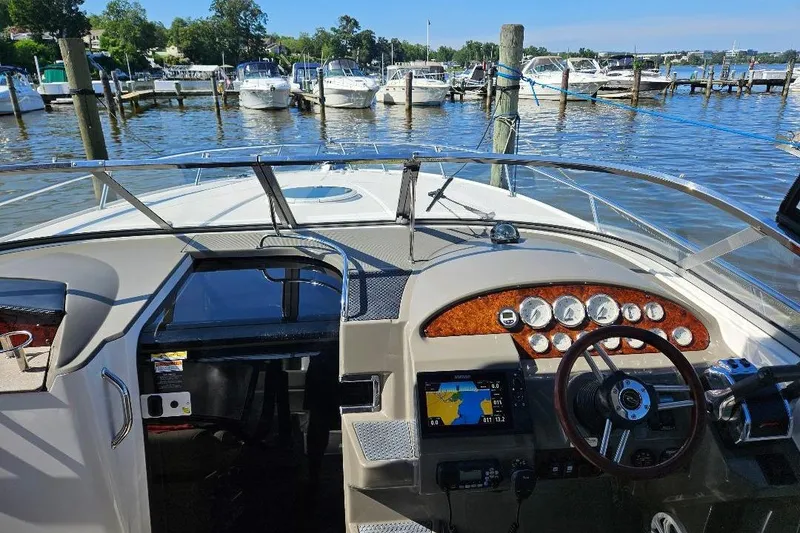 Slide: The Image of 2010 Regal 3350 Cuddy boat dashboard with marina view in the background. - 2