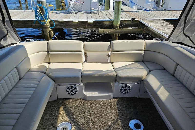 Slide: The Image of 2010 Regal 3350 Cuddy boat interior with beige seating and dock view. - 3