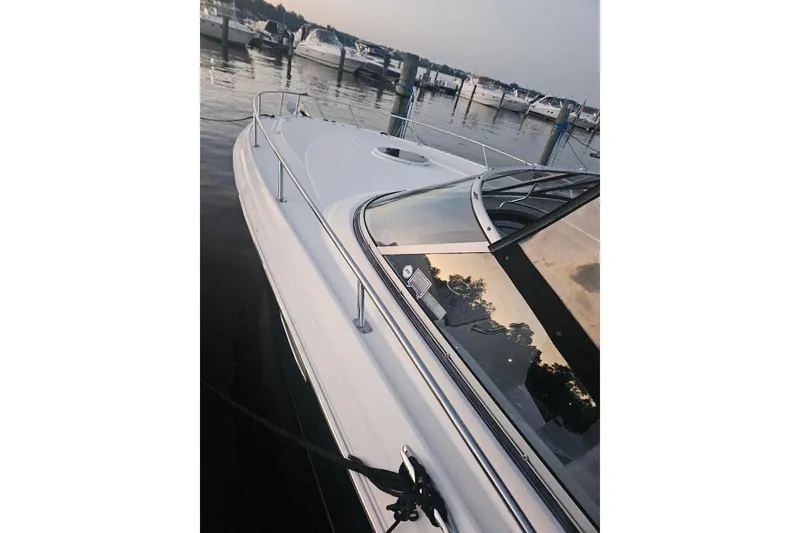 Slide: The Image of 2010 Regal 3350 Cuddy boat docked at marina, sleek design, calm waters. - 4