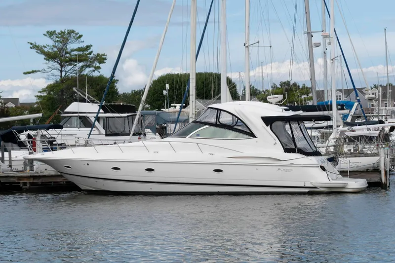 The Image of 2007 Cruisers Yachts 460 Express docked in a marina, surrounded by sailboats. - 0