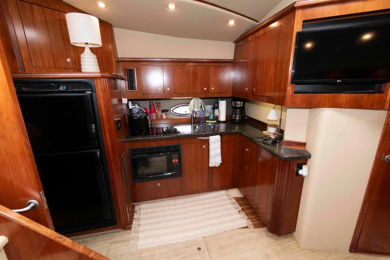 Slide: The Image of Luxurious 2007 Cruisers Yachts 460 Express kitchen with wood cabinetry and modern appliances. - 13