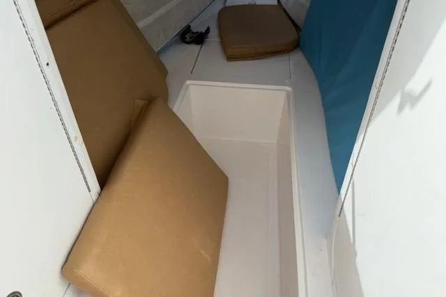 Slide: The Image of 2005 Dakota 36 CC Forward Cuddy Cabin interior with beige cushions and storage space. - 17