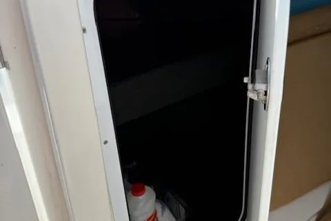 Slide: The Image of 2005 Dakota 36 CC Forward Cuddy Cabin interior storage compartment with door ajar. - 18