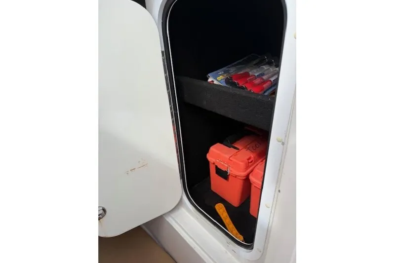 Slide: The Image of Open storage compartment in 2005 Dakota 36 CC Forward Cuddy Cabin with tools and supplies. - 19