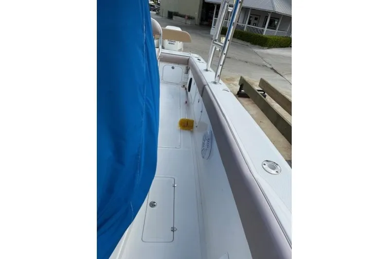 Slide: The Image of 2005 Dakota 36 CC Forward Cuddy Cabin boat deck with blue cover and cleaning brush. - 22