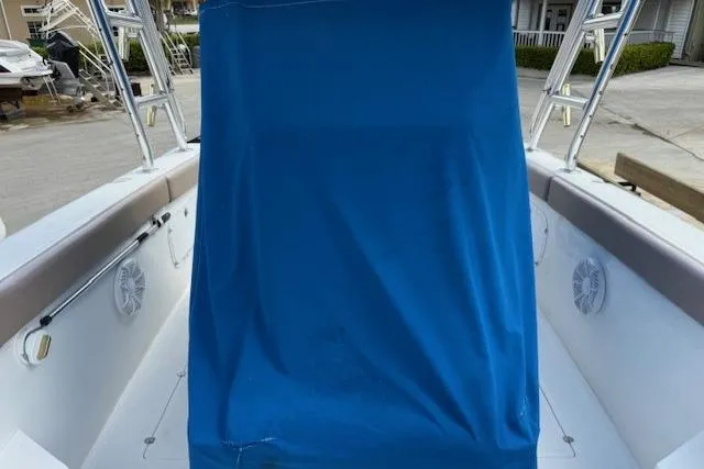 Slide: The Image of 2005 Dakota 36 CC Forward Cuddy Cabin with blue cover in marina setting. - 23