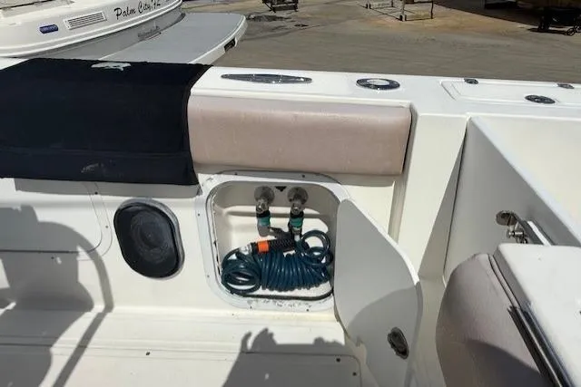 Slide: The Image of 2005 Dakota 36 CC Forward Cuddy Cabin boat deck with storage compartment and hose. - 30