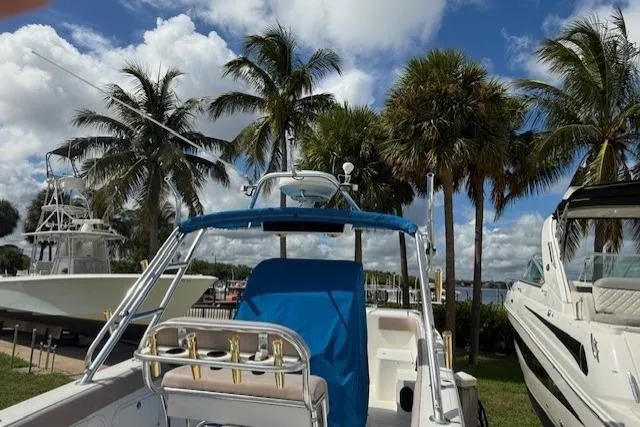 Slide: The Image of 2005 Dakota 36 CC Forward Cuddy Cabin boat docked, surrounded by palm trees and blue sky. - 4