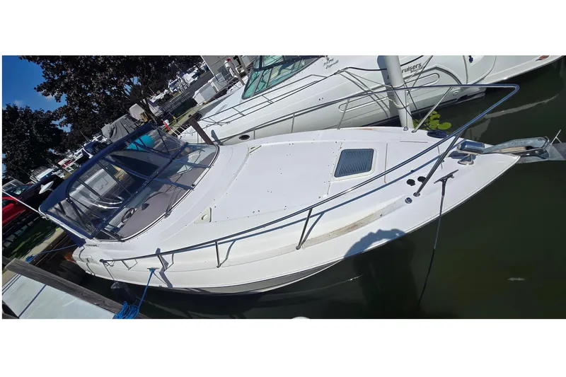 Slide: The Image of 2004 Regal Commodore 3260 boat docked at marina, featuring sleek design and spacious deck. - 2