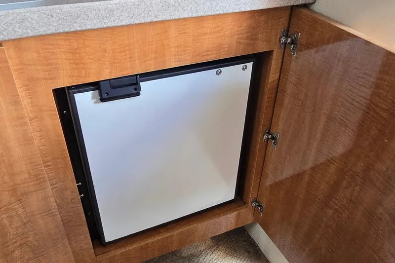 Slide: The Image of 2004 Regal Commodore 3260 yacht interior kitchen with wooden cabinetry and stainless steel sink. - 21