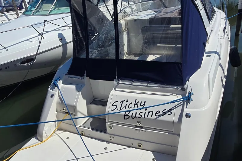 Slide: The Image of 2004 Regal Commodore 3260 boat named "Sticky Business" docked at a marina. - 3