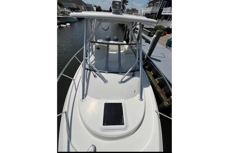 Slide: The Image of 2011 Sailfish 2660 WAC boat docked, featuring a sleek white deck and sturdy railings. - 10