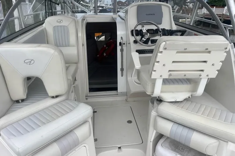 Slide: The Image of 2011 Sailfish 2660 WAC boat interior with white seating and steering console. - 12